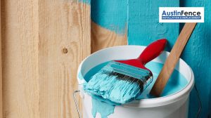 paint bucket in front of wooden fence